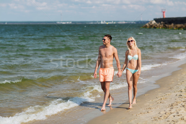 Stock photo: happy couple in swimwear walking on summer beach