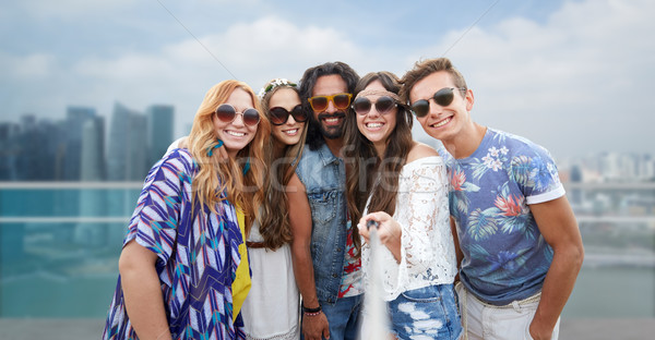 happy hippie friends with selfie stick over city Stock photo © dolgachov