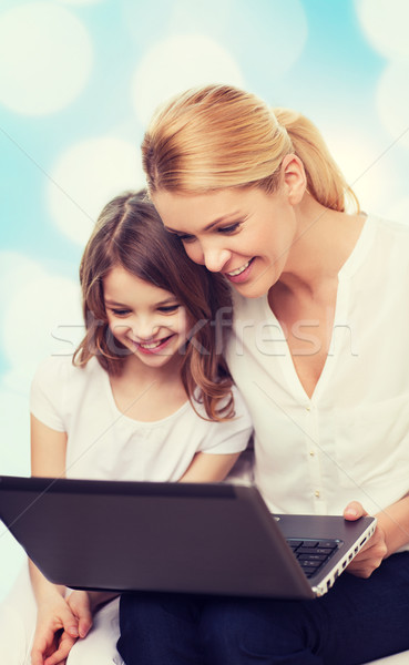 smiling mother and little girl with laptop Stock photo © dolgachov
