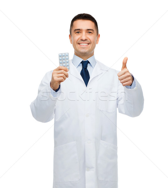 smiling male doctor in white coat with tablets Stock photo © dolgachov