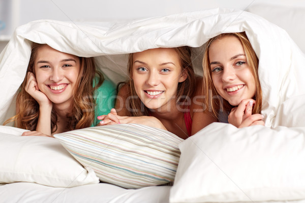 happy young women in bed at home pajama party Stock photo © dolgachov