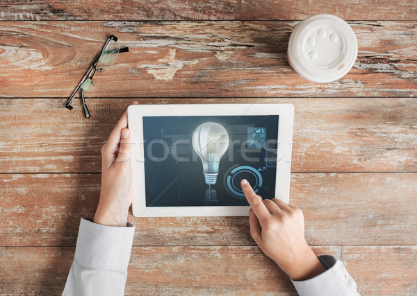 close up of hands with tablet pc and lighting bulb Stock photo © dolgachov