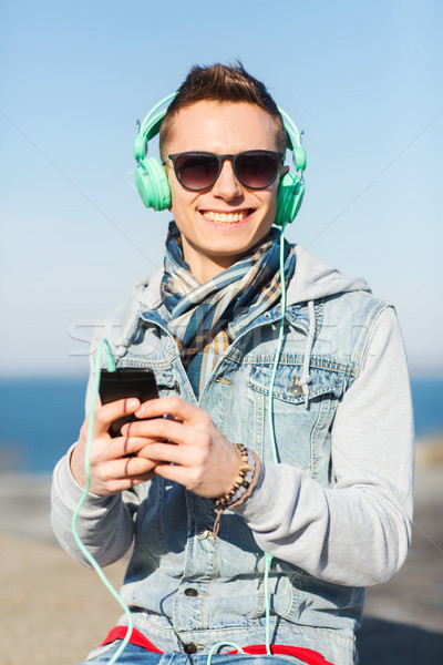 Szczęśliwy młody człowiek słuchawki smartphone technologii życia Zdjęcia stock © dolgachov