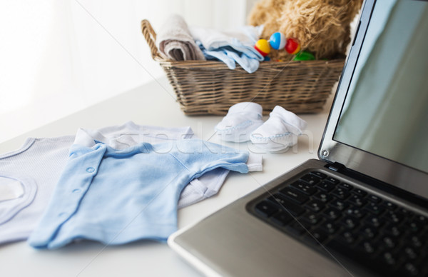 close up of baby clothes, toys and laptop at home Stock photo © dolgachov