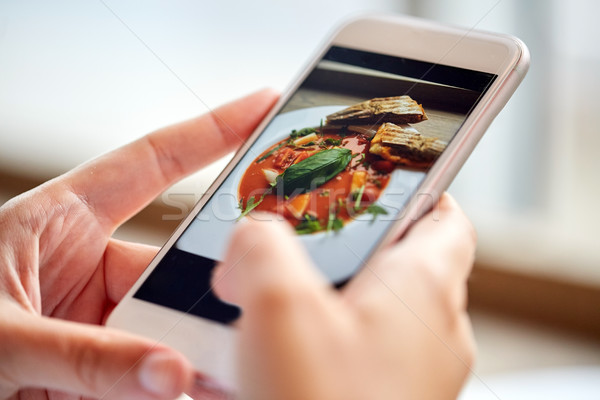 hands with gazpacho soup photo on smartphone at restaurant Stock photo © dolgachov
