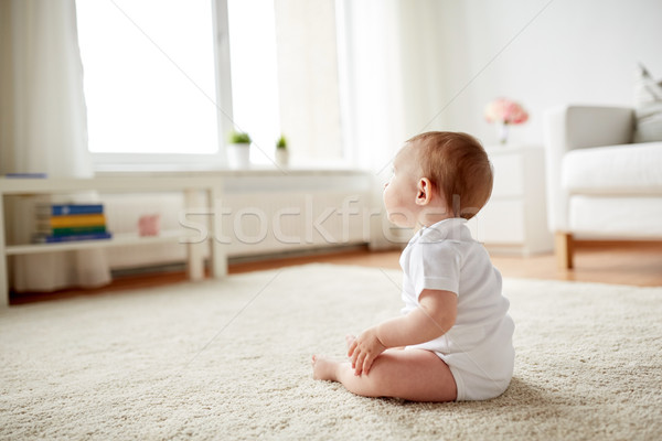 happy baby boy or girl sitting on floor at home Stock photo © dolgachov