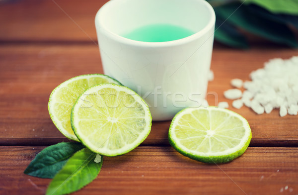 close up of body lotion in cup and limes on wood Stock photo © dolgachov