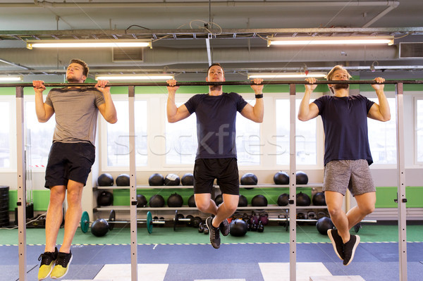 group of young men doing pull-ups in gym Stock photo © dolgachov