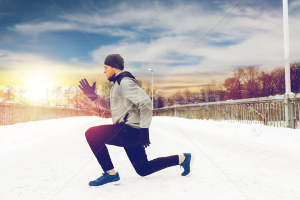 man exercising and doing squats on winter bridge Stock photo © dolgachov