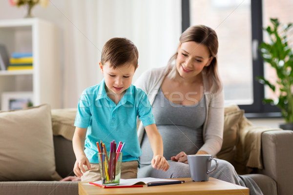 pregnant mother and son with workbook at home Stock photo © dolgachov