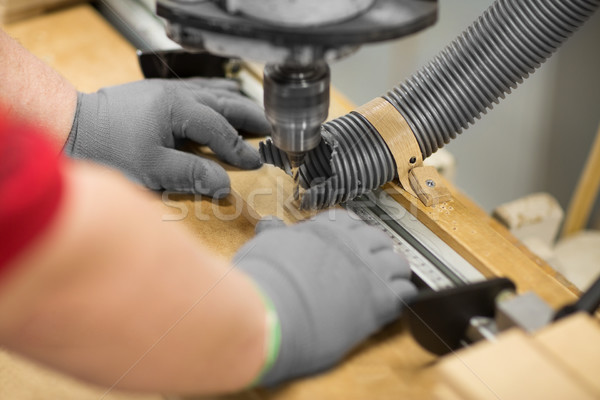 carpenter with drill press and board at workshop Stock photo © dolgachov