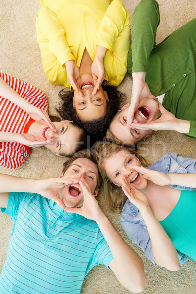 smiling people lying down on floor and screaming Stock photo © dolgachov