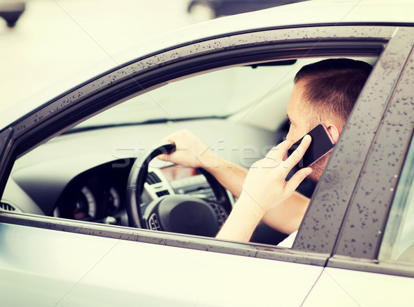 Stock photo: man using phone while driving the car