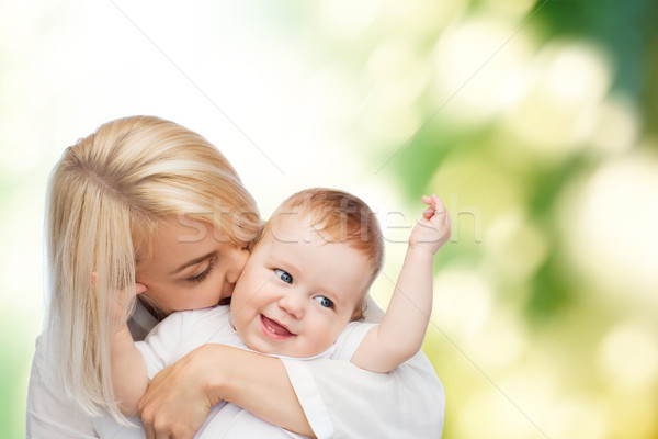 Stock photo: happy mother kissing smiling baby