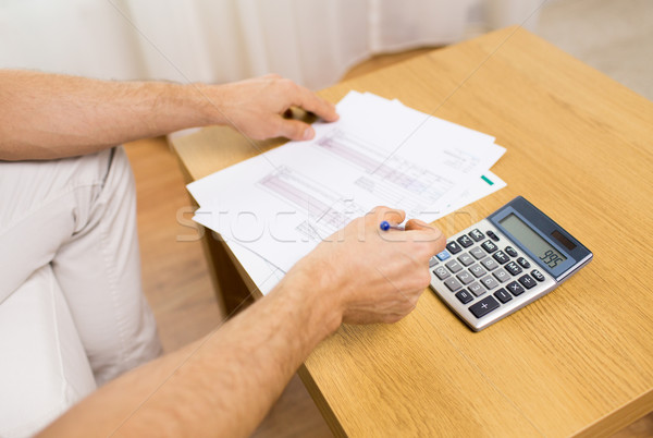 close up of man with papers and calculator at home Stock photo © dolgachov