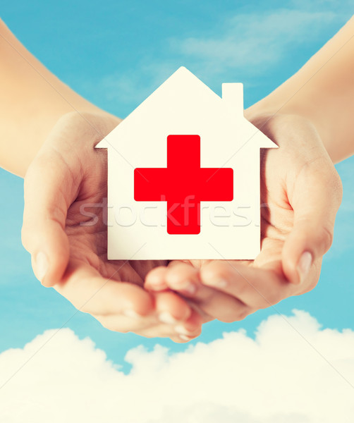 Stock photo: hands holding paper house with red cross