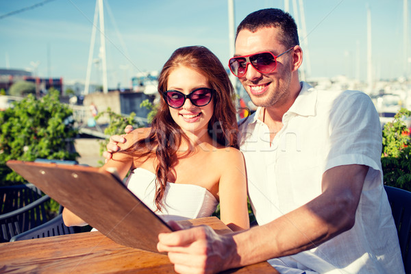 Stock photo: smiling couple with menu at cafe