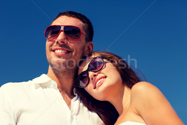 smiling couple over blue sky background Stock photo © dolgachov