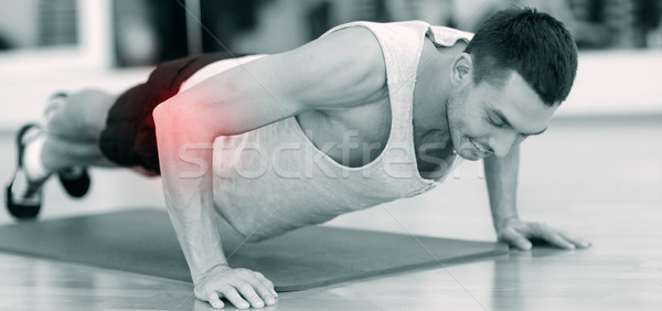 smiling man doing push-ups in gym Stock photo © dolgachov