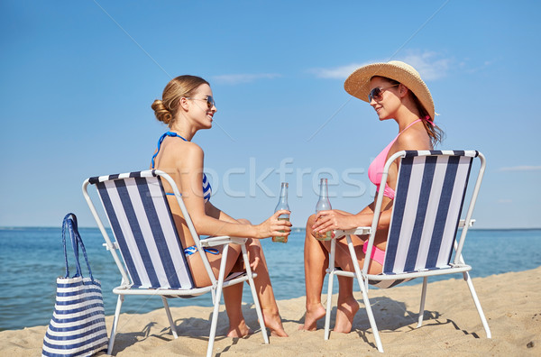 happy women sunbathing in lounges on beach Stock photo © dolgachov