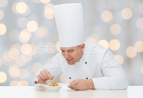 happy male chef cook decorating dish Stock photo © dolgachov