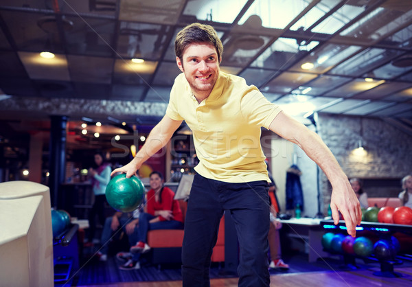 happy young man throwing ball in bowling club Stock photo © dolgachov