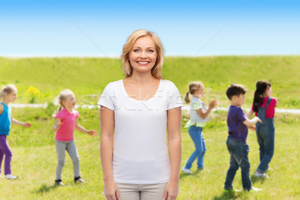 Glimlachende vrouw groep weinig kinderen buitenshuis moederschap Stockfoto © dolgachov