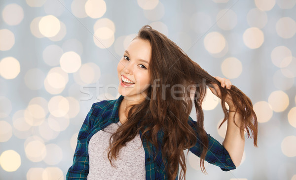 happy teenage girl holding strand of her hair Stock photo © dolgachov