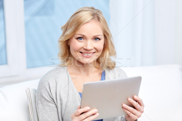 happy middle aged woman with tablet pc at home Stock photo © dolgachov