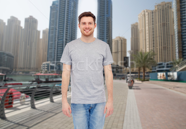 young man in gray t-shirt and jeans over city  Stock photo © dolgachov