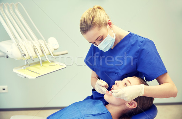 Stock photo: female dentist checking patient girl teeth