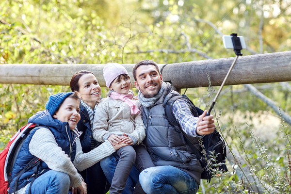 happy family with smartphone selfie stick in woods Stock photo © dolgachov