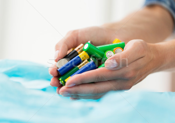 close up of hands putting batteries to rubbish bag Stock photo © dolgachov