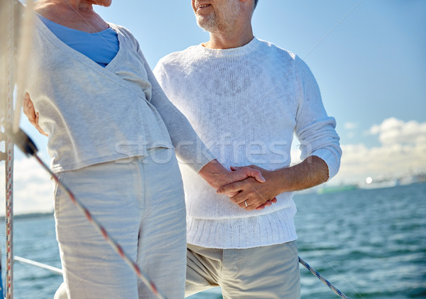 Stock photo: happy senior couple on sail boat or yacht in sea