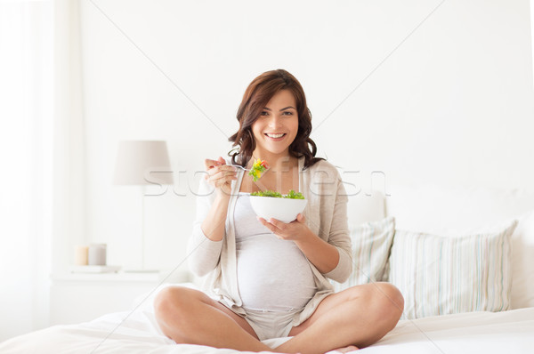 happy pregnant woman eating salad at home Stock photo © dolgachov
