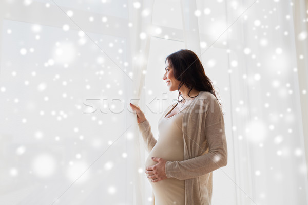 happy pregnant woman looking to window Stock photo © dolgachov