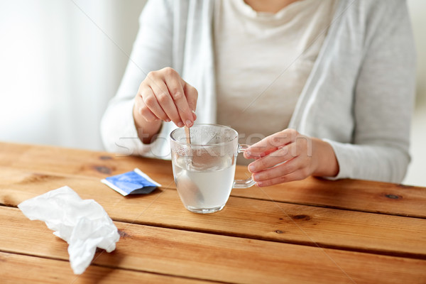 Stock photo: woman stirring medication in cup with spoon