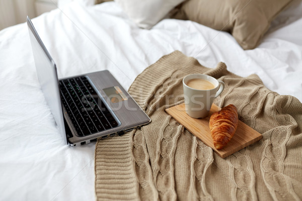 筆記本電腦 咖啡 新月形麵包 床 家 商業照片 © dolgachov