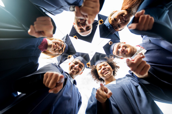 Stock photo: happy students or bachelors pointing finger at you