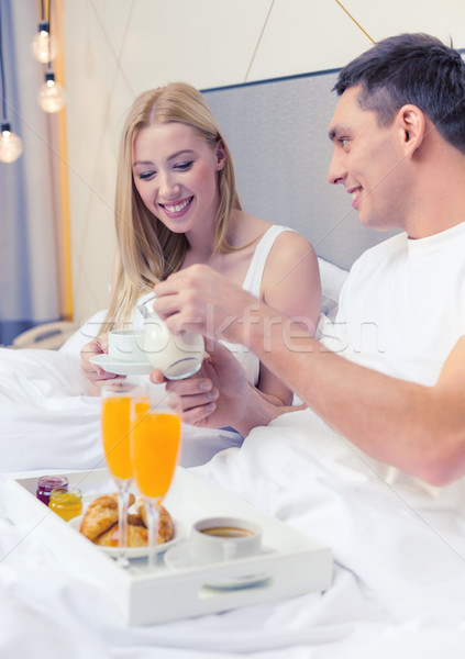 smiling couple having breakfast in bed in hotel Stock photo © dolgachov