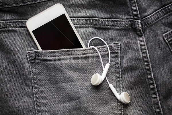 smartphone and earphones in denim or jeans pocket Stock photo © dolgachov
