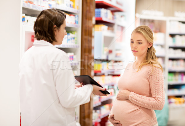 pregnant woman and druggist at pharmacy Stock photo © dolgachov