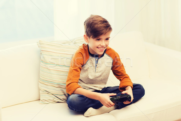 happy boy with joystick playing video game at home Stock photo © dolgachov