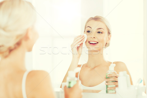 young woman with lotion washing face at bathroom Stock photo © dolgachov
