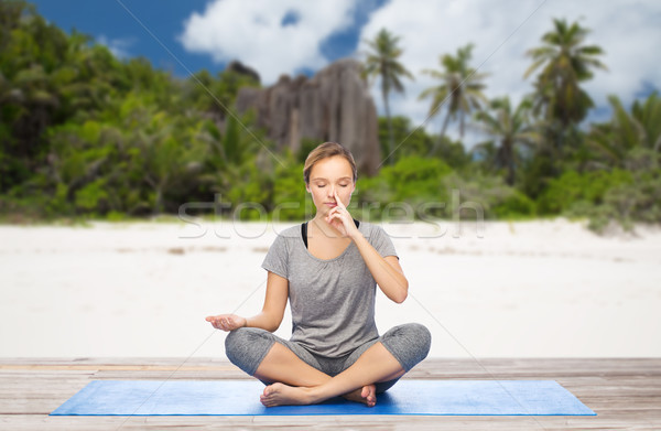 woman doing yoga breathing exercise on beach Stock photo © dolgachov