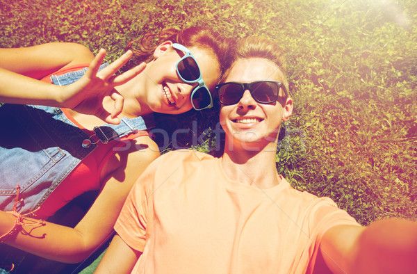 happy teenage couple taking selfie on summer grass Stock photo © dolgachov