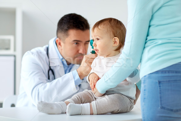 doctor checking baby ear with otoscope at clinic Stock photo © dolgachov