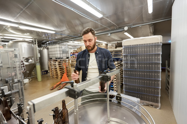 men with bottles on conveyor at craft beer brewery Stock photo © dolgachov