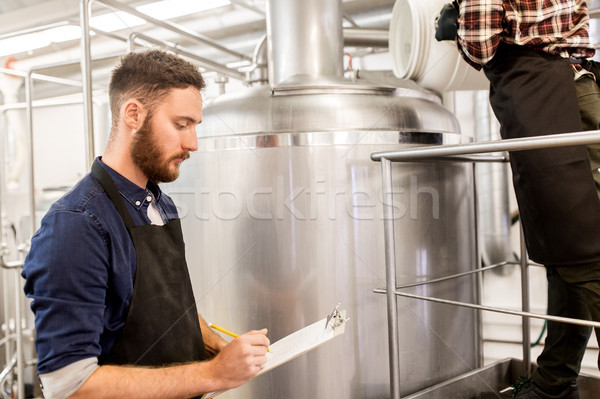 men working at craft brewery or beer plant Stock photo © dolgachov