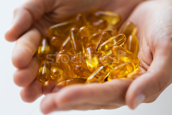 Kezek tart máj olaj kapszulák gyógyszer Stock fotó © dolgachov